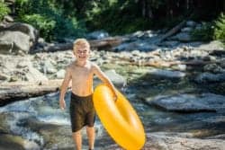 boy with yellow inner tube on river